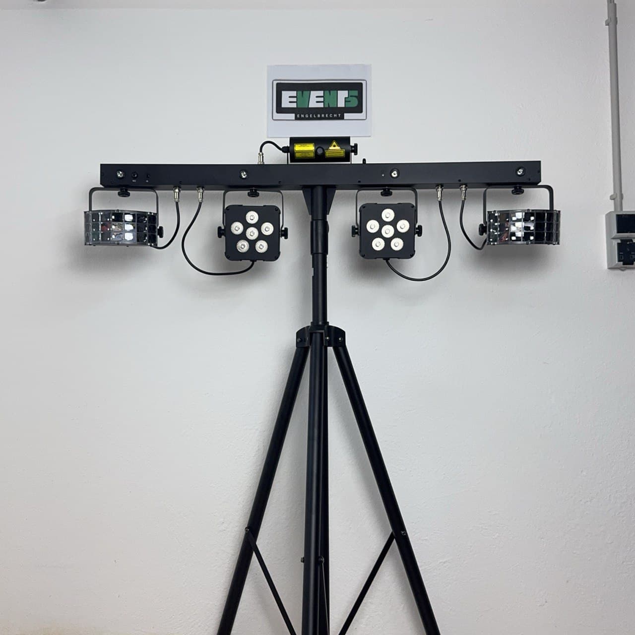 Beleuchtungsausrüstung auf einem Stativ mit vier LED-Leuchten und einem Bedienfeld an einer schlichten Wand.