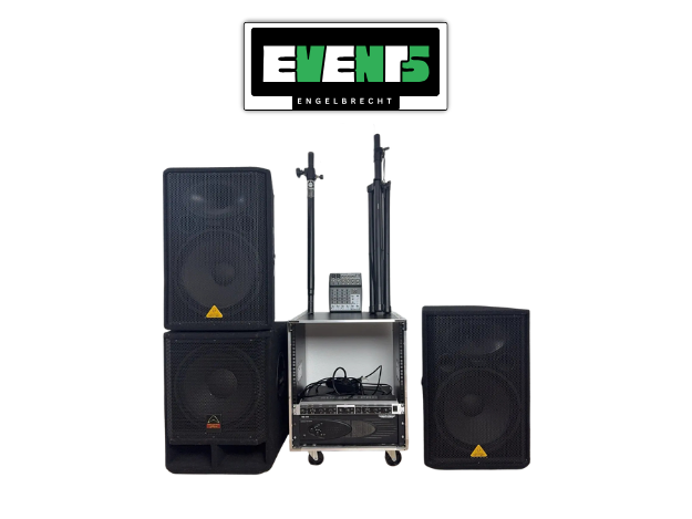 Audiogeräte-Setup mit zwei großen Lautsprechern, einem Mixer, Ständern und Kabeln, ordentlich organisiert auf einem Regal vor einer weißen Wand.