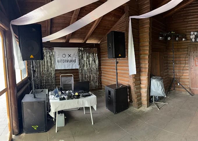 Bild von Lautsprechern in einer Grillhütte mit weißer Dekoration.